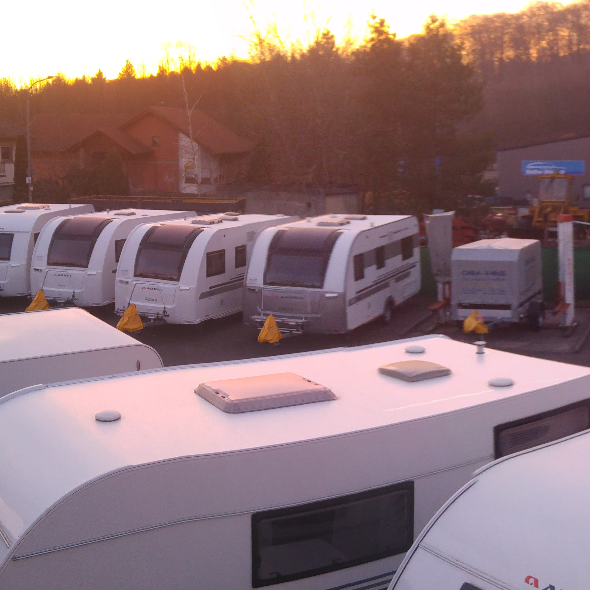 Stellplatzgelände von CARA-VANS mit Wohnwagen im Abendlicht